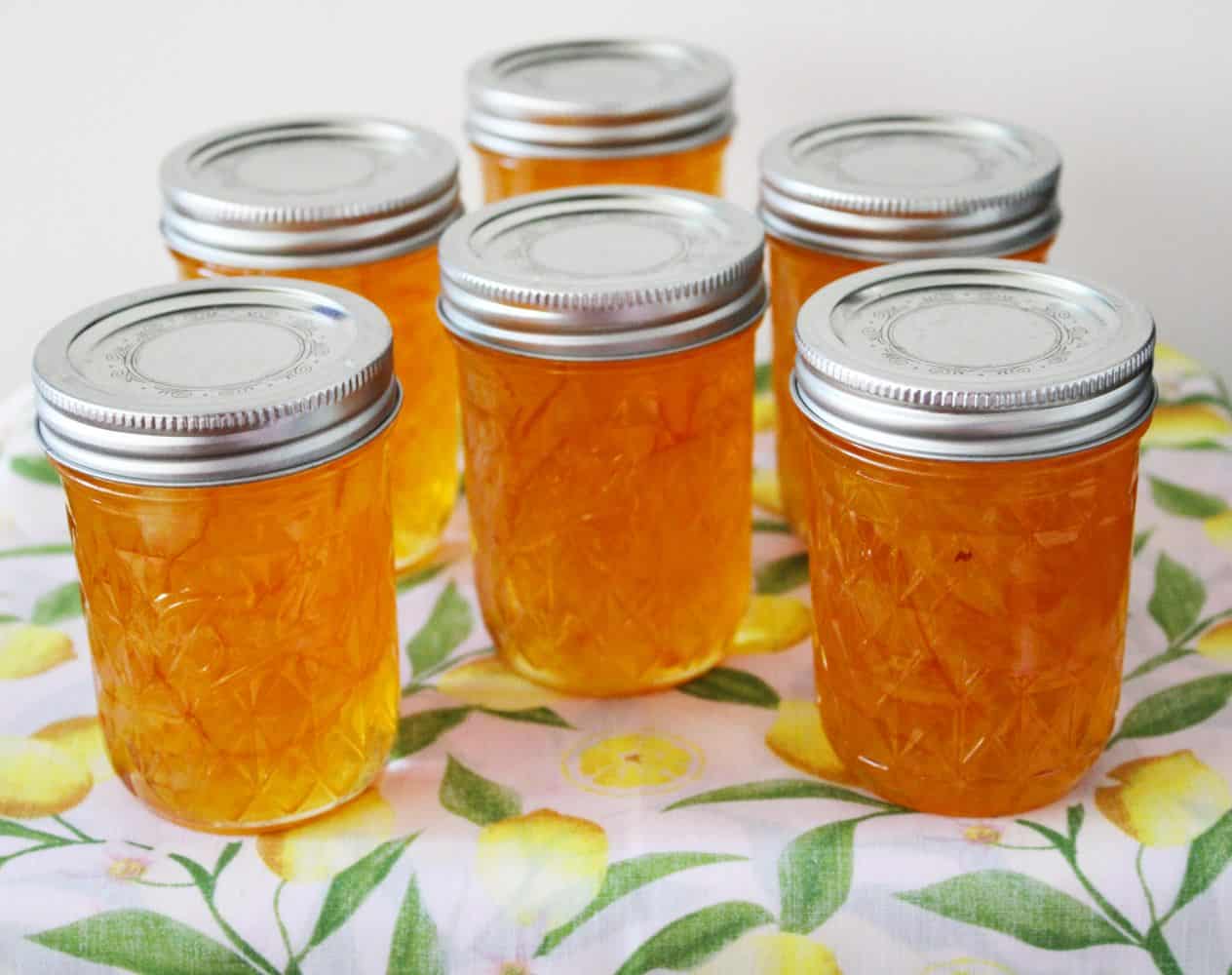 Six jars of Lemon Marmalade on a lemon cloth. 