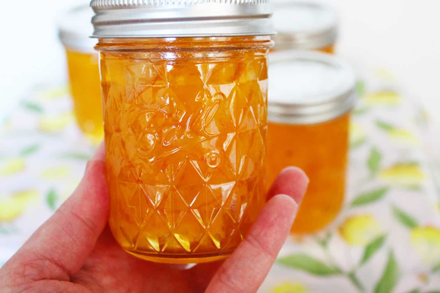 Holding up a jar of Lemon Marmalade. 