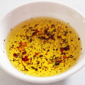 Up close shot of round white dish with dipping oil.