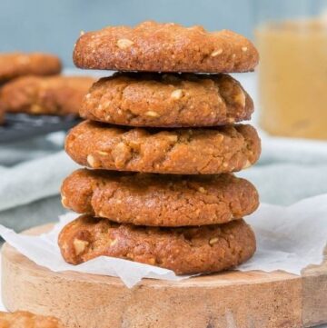 stack of cookies sitting on a round wooden board.