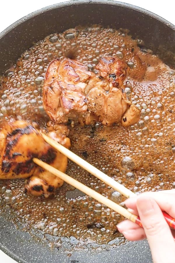 preparing teriyaki chicken using chopsticks.