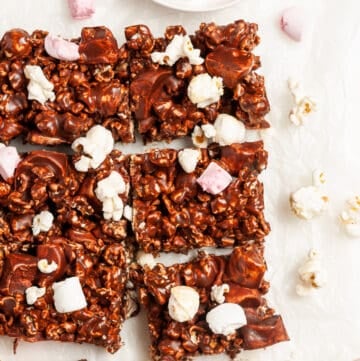 up close shot of cut bars with some extra popcorn and marshmallows sprinkled on top.