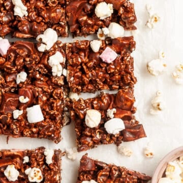 overhead shot of cut popcorn bars, with some popcorn and marshmallows sprinkled around the edge.