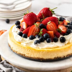 Shot of cheesecake decorated with cream and fruit.