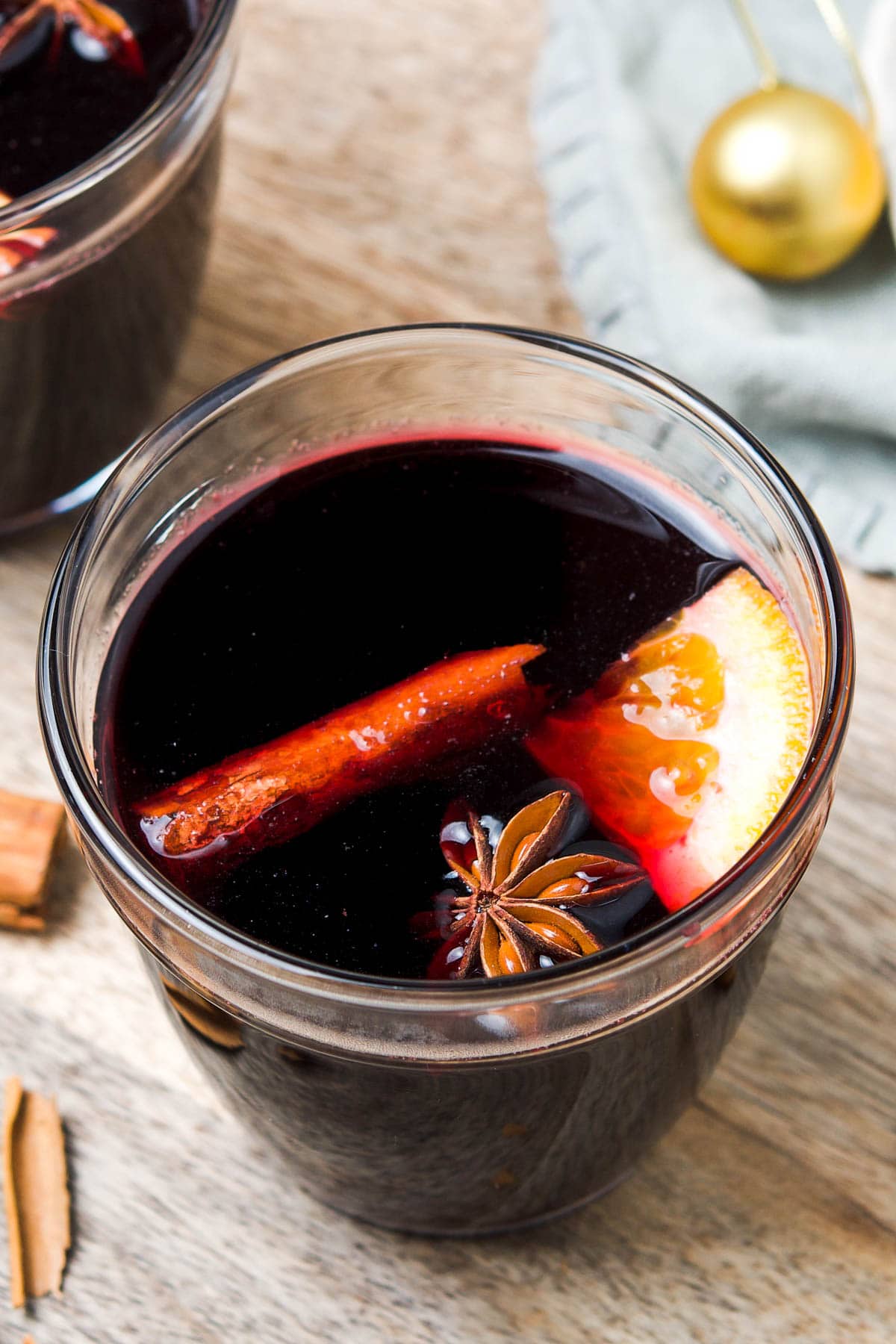 Up close shot of glass with wine in it, with some cinnamon, star anise and orange.