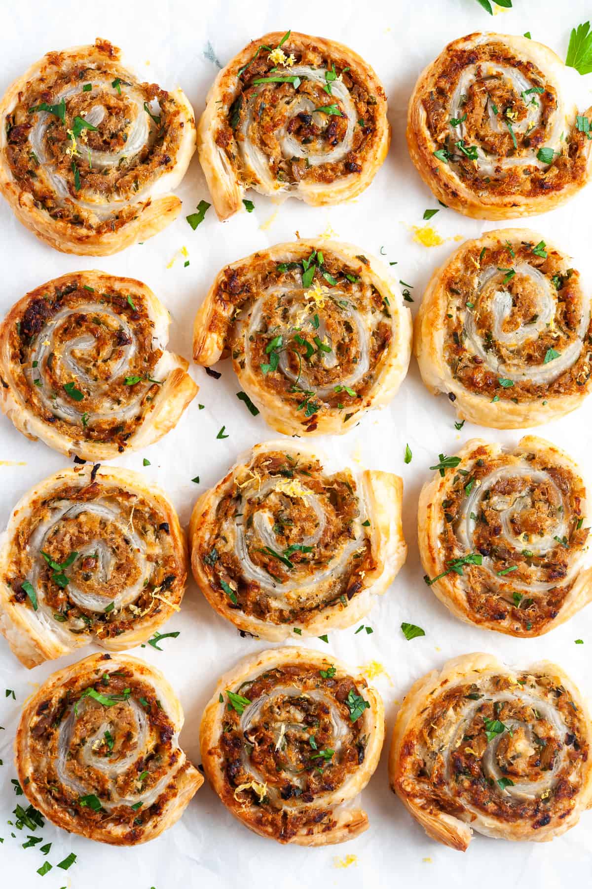 Overhead shot of cooked pinwheels on baking paper.