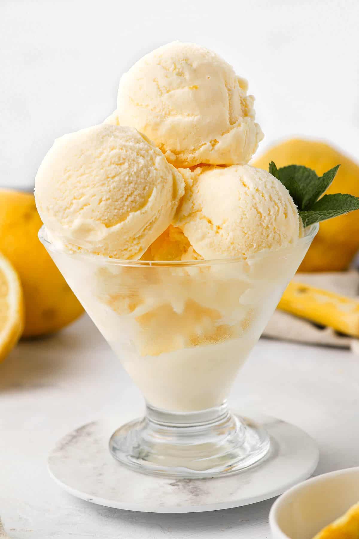 Three scoops of ice cream in a glass dish, garnished with mint.