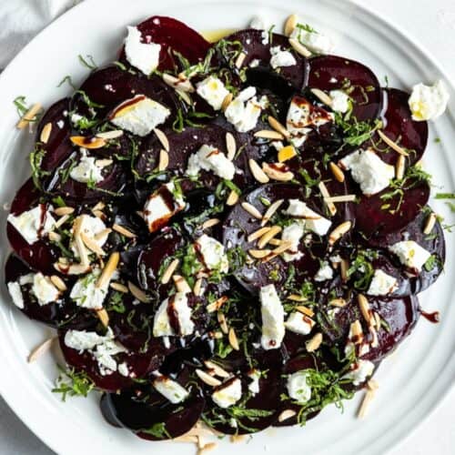 Round white plate with beetroot salad.