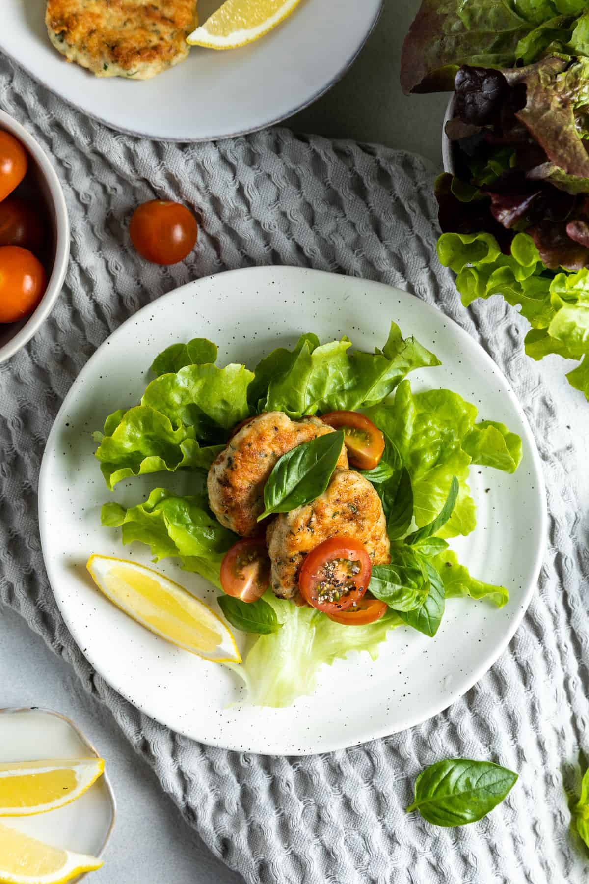 Serve of chicken patties on a bed of salad.
