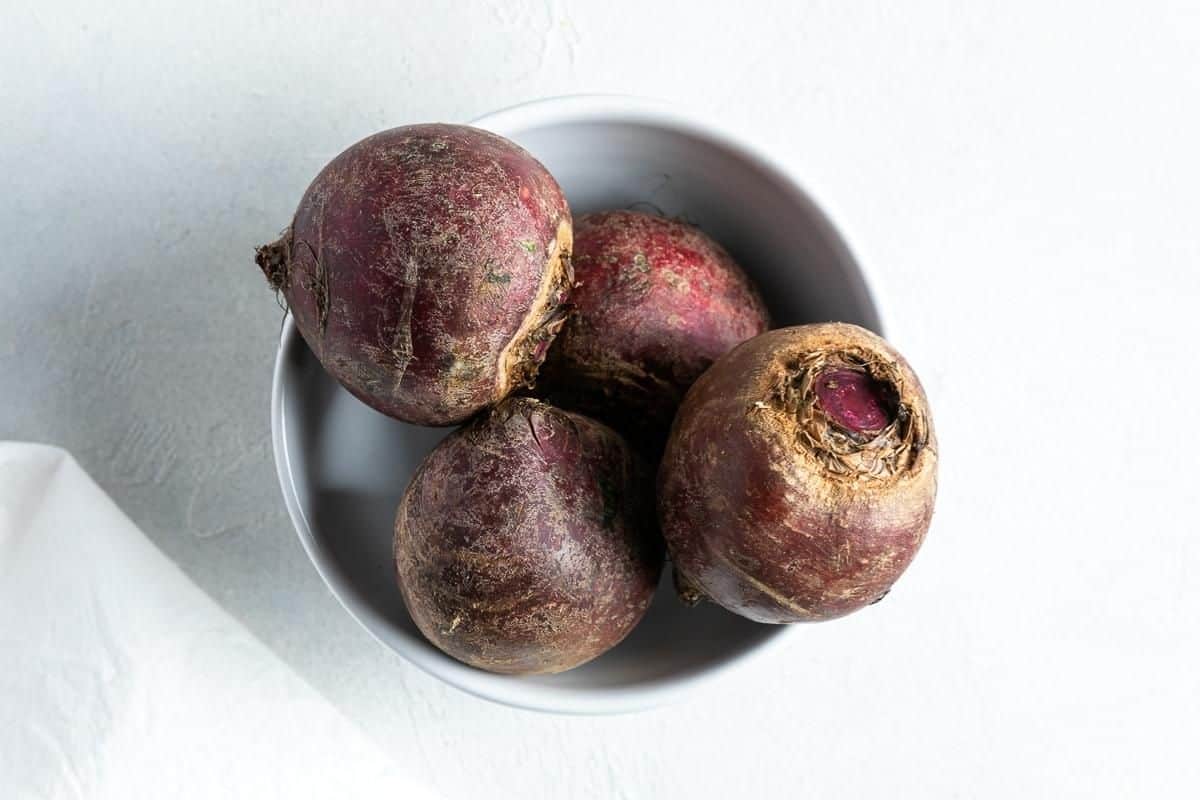 Ingredients in recipe - a bowl of four uncooked beetroot.