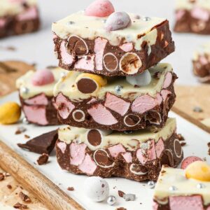 Three pieces of rocky road stacked, sitting on a board.