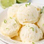 Bowl with several scoops of ice cream, garnished with lime zest.