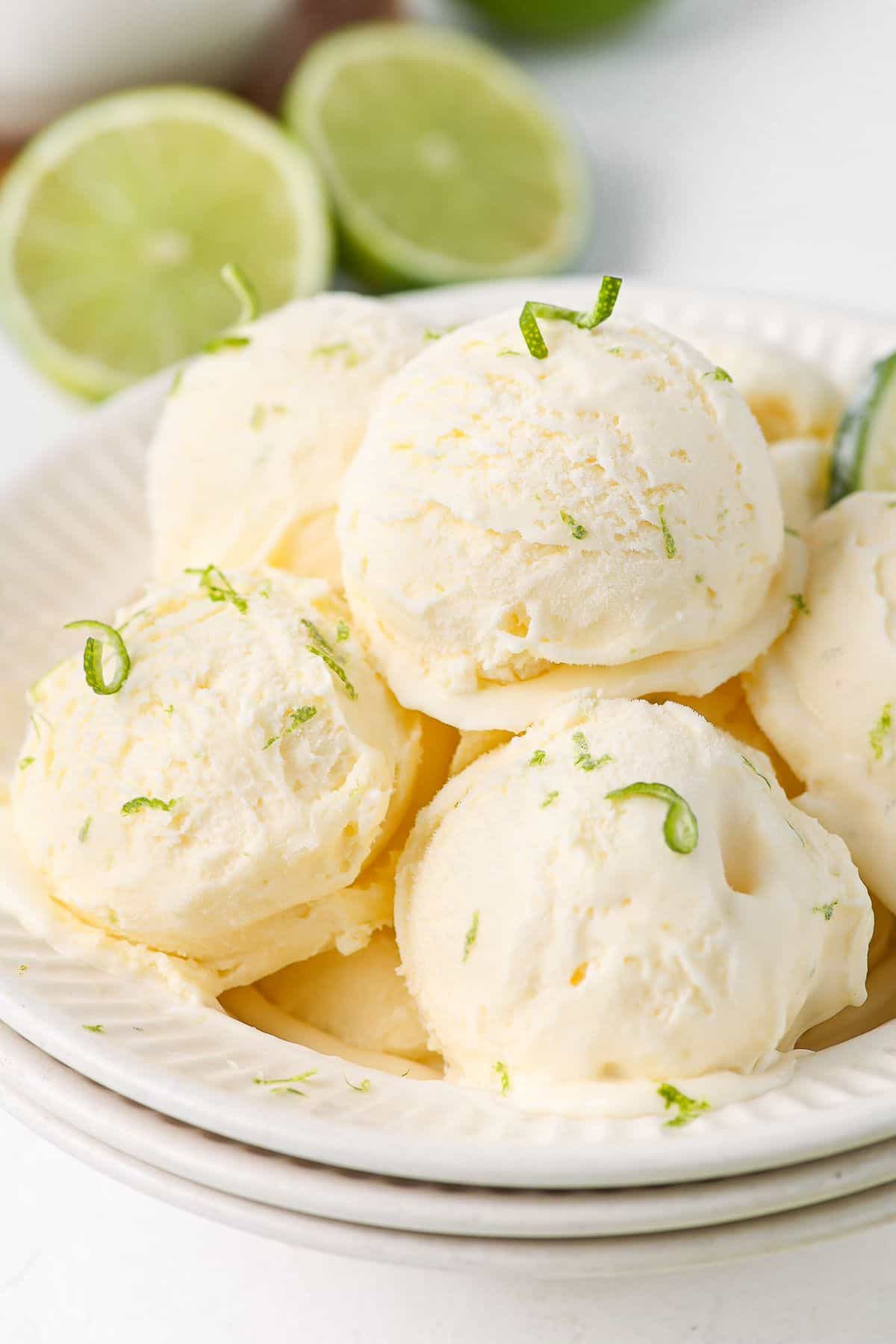 Bowl with several scoops of ice cream, garnished with lime zest.