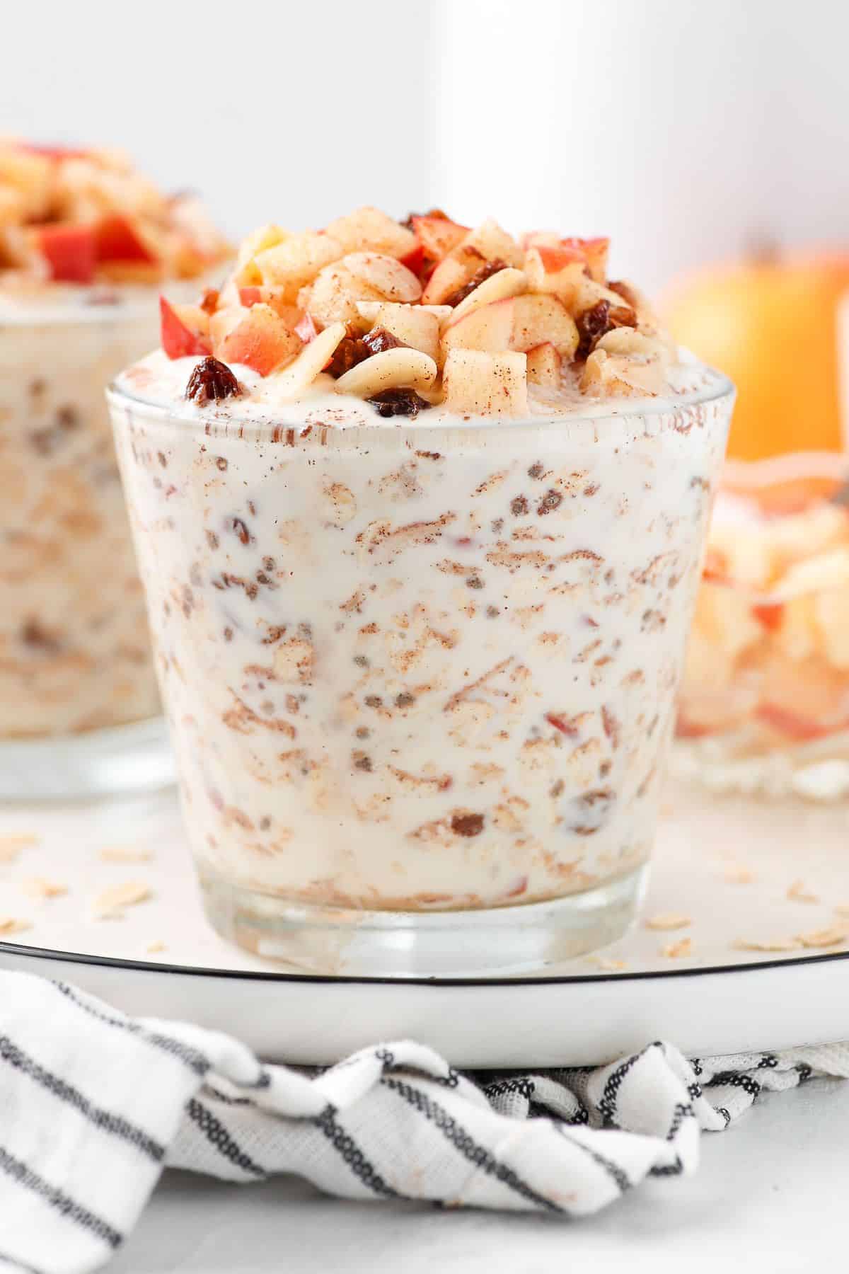 Glass with overnight oats, topped with cubes of apple.