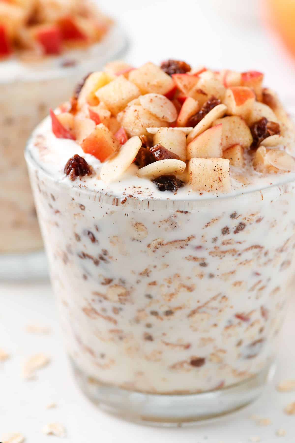 Glass with overnight oats, topped with cubes of apple.