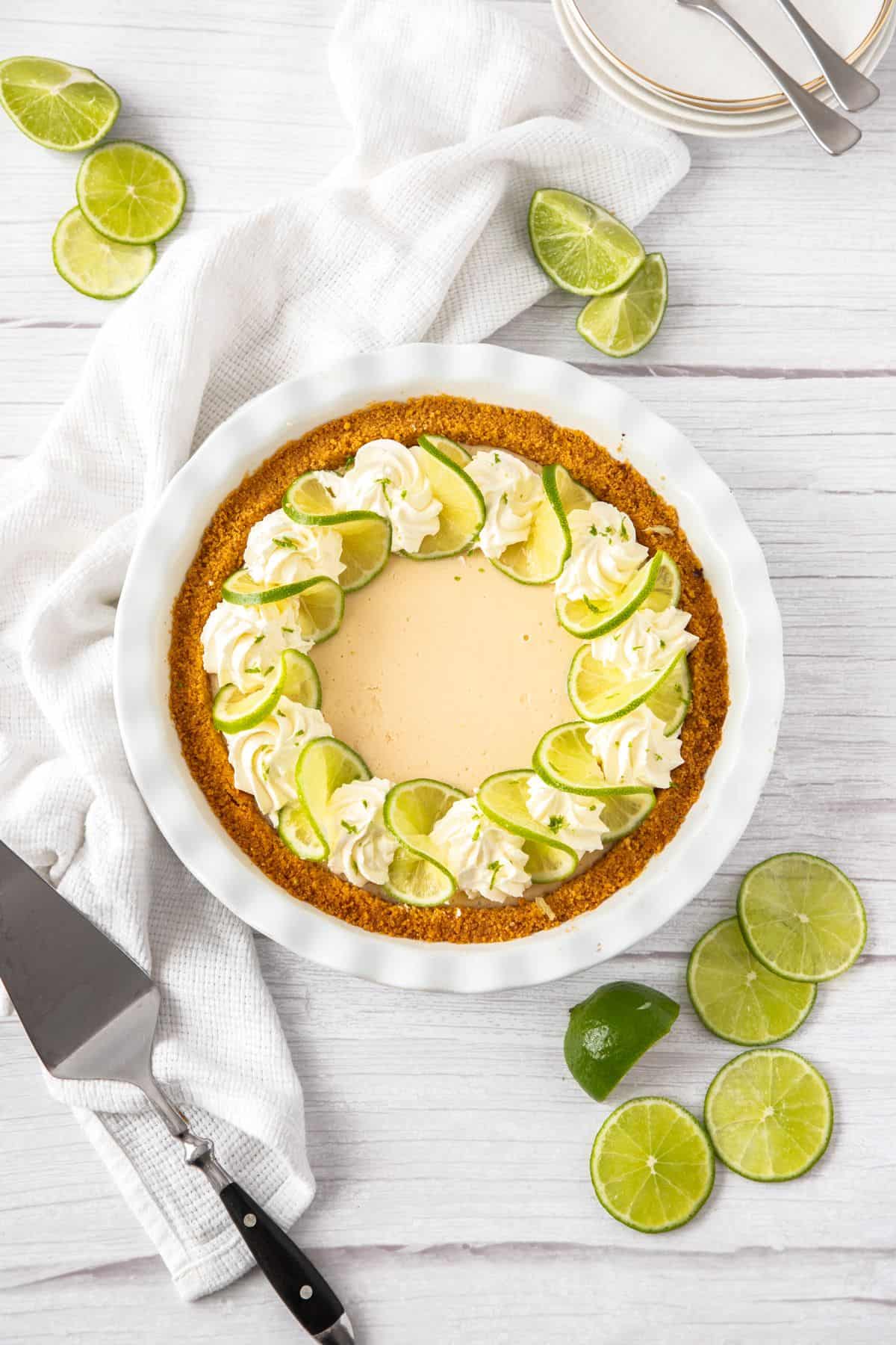 Overhead shot of whole key lime pie, sitting on a white cloth.