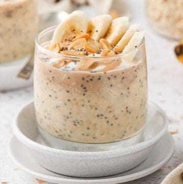 Jar of overnight oats, garnished with some peanuts and banana slices.