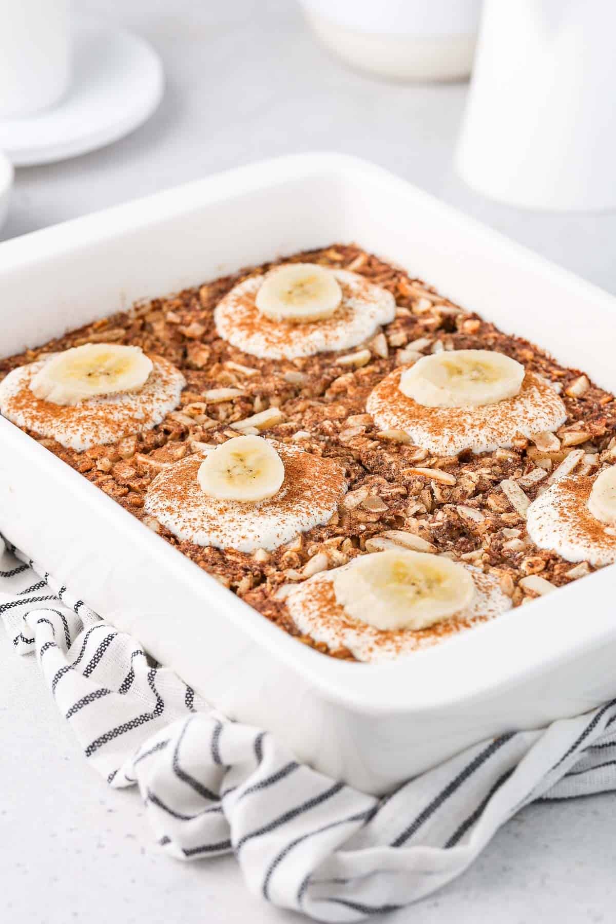 White rectangular dish of baked banana oatmeal, cut into six pieces.