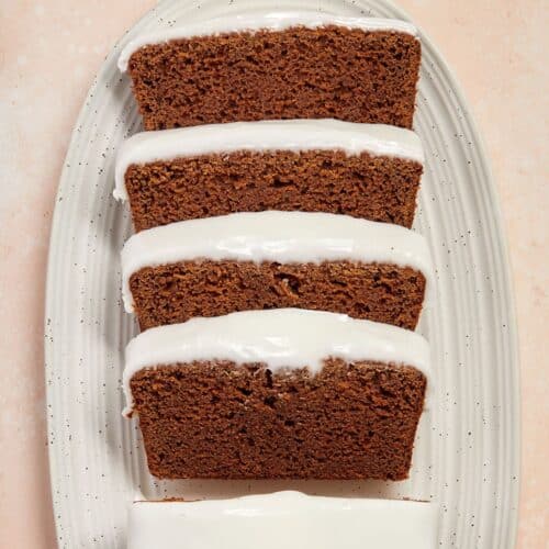 Slices of gingerbread loaf, sitting on a white oval dish.