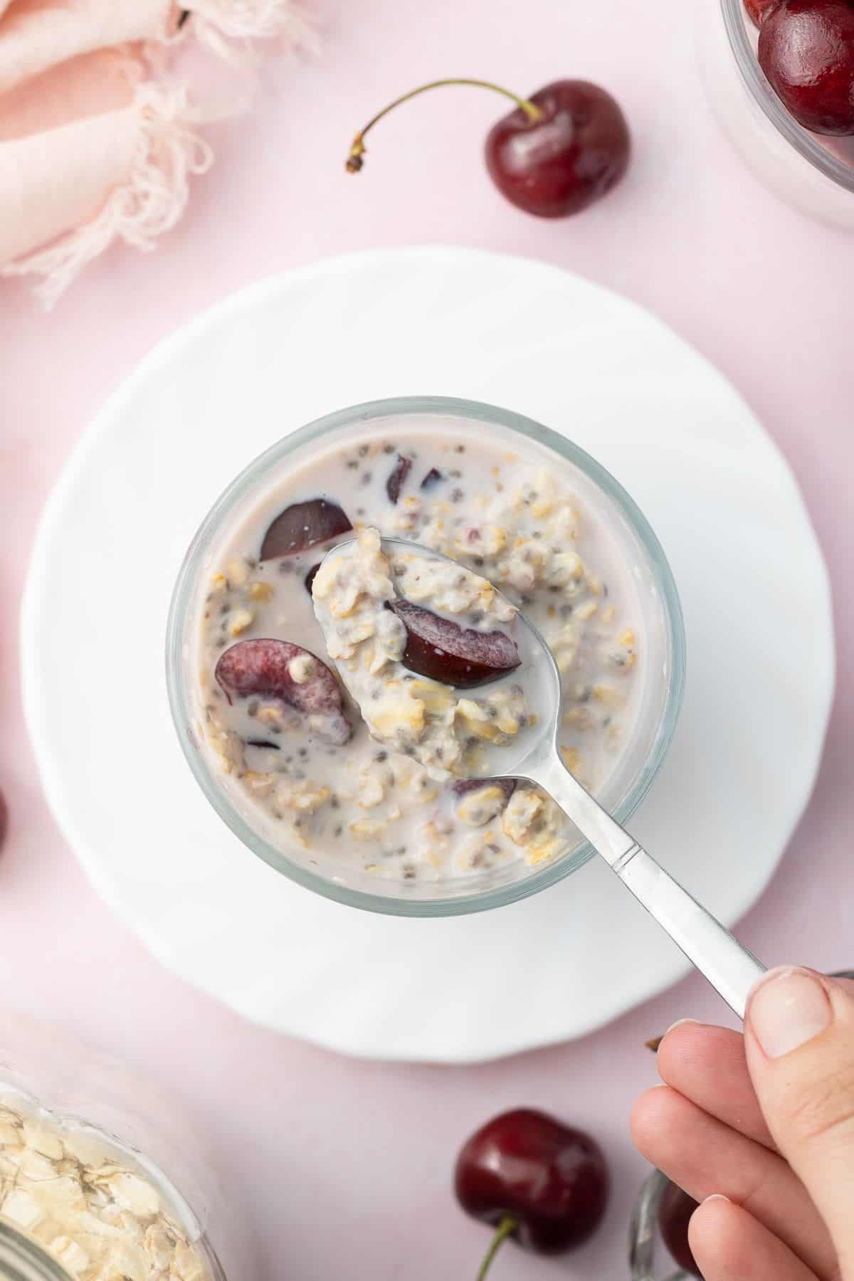 Spoon dipping in to glass jar of overnight oats.
