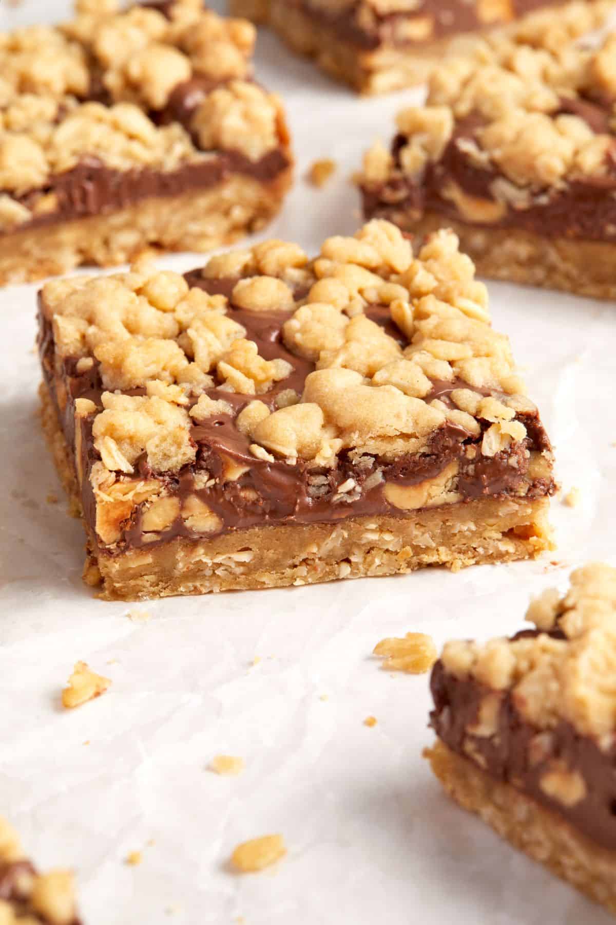 Cut squares of Nutella Oatmeal Bars sitting on some baking paper.