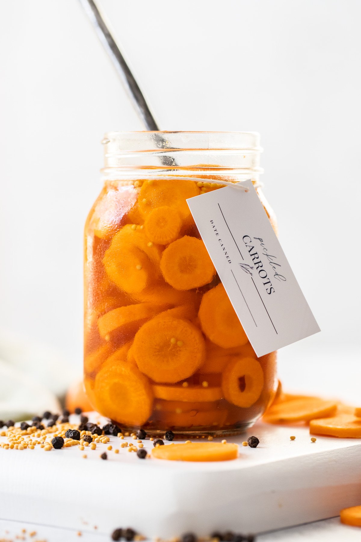 Jar of Pickled Carrots with a spoon resting in the jar.