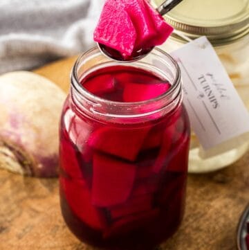 Spoon lifting some Beetroot Pickled Turnips out of the jar.