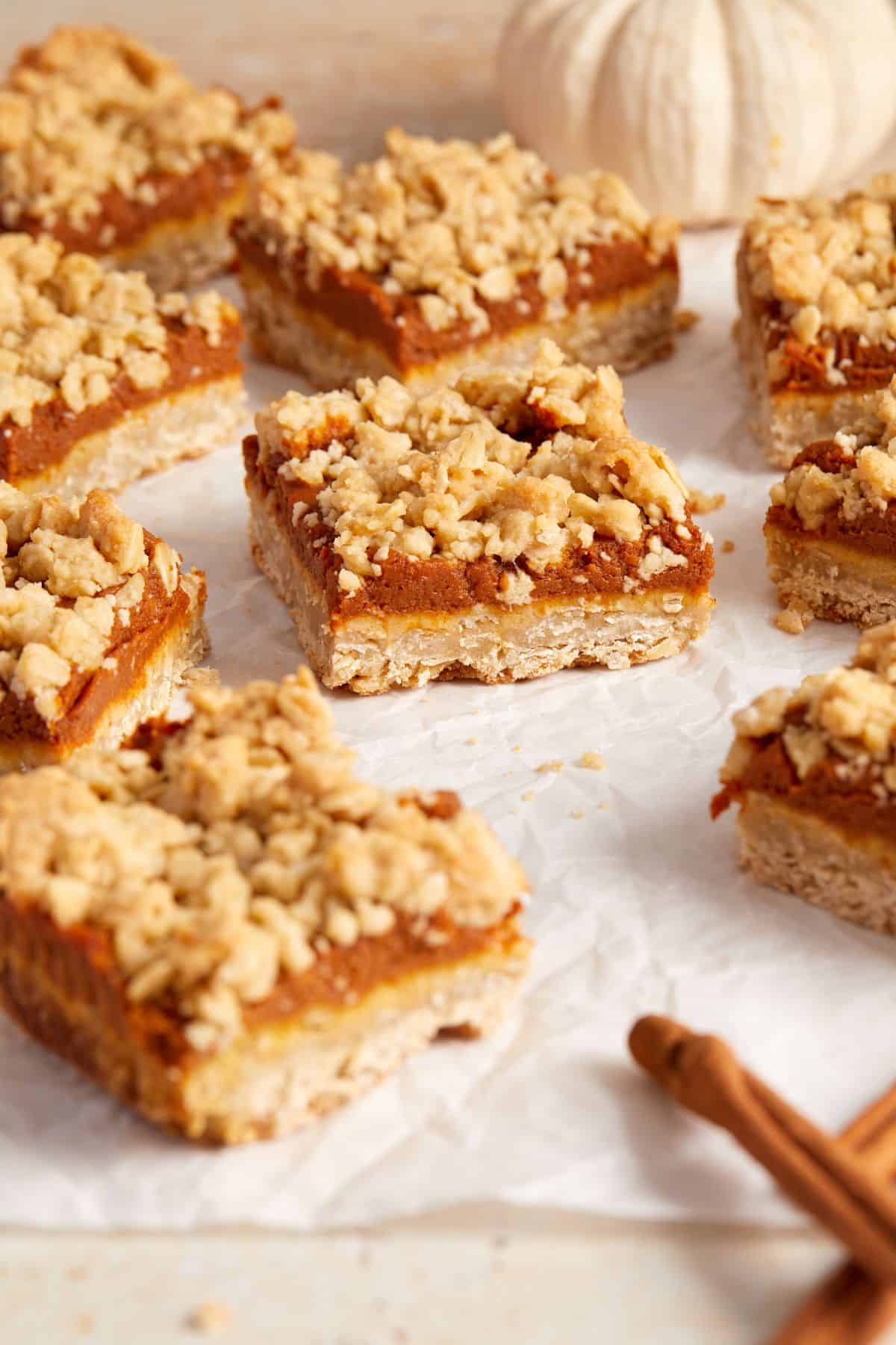 Cut squares of Pumpkin Oatmeal Bars, sitting on some baking paper.
