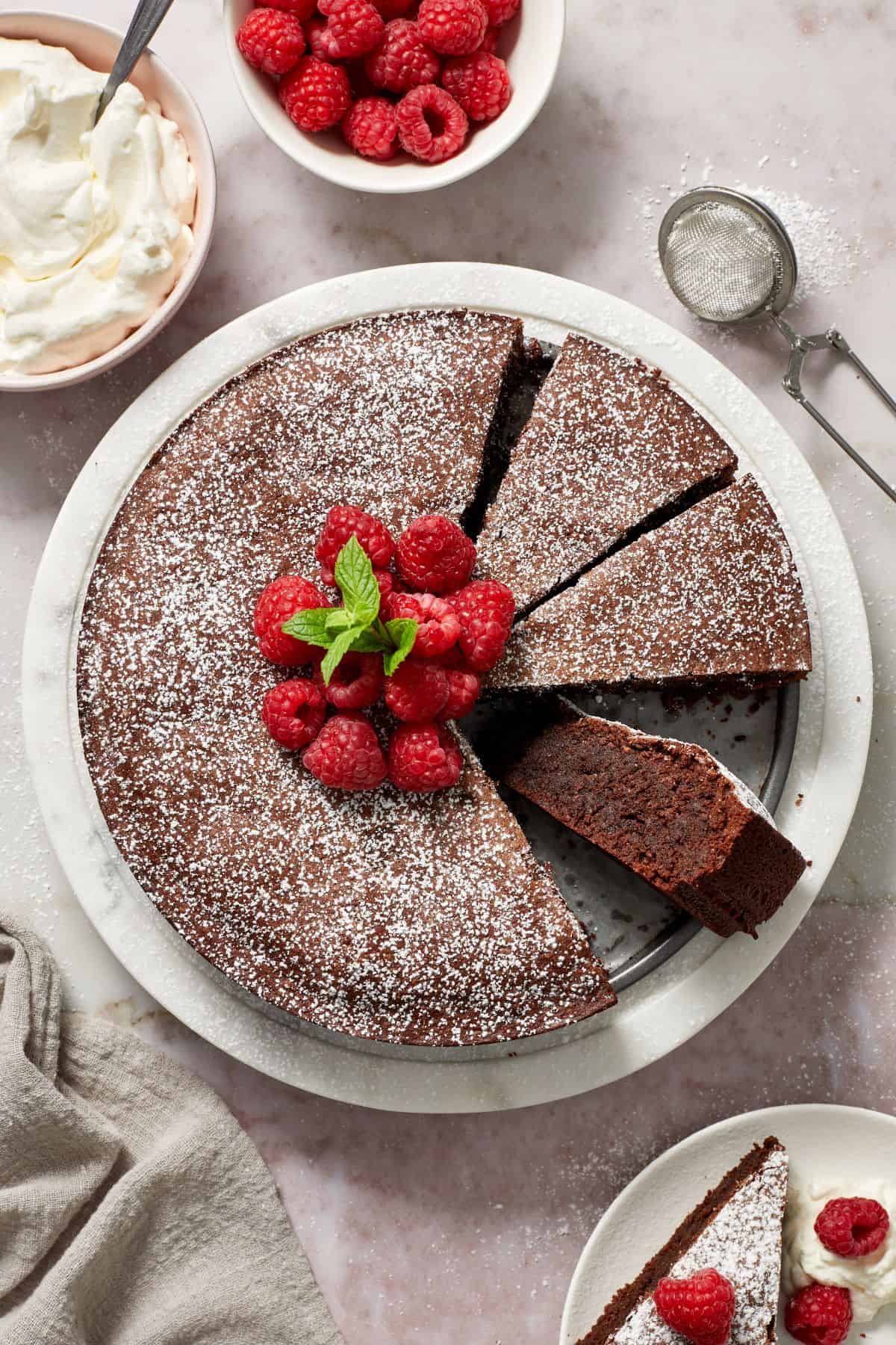 Torta Caprese with three pieces cut, and one laying on the side showing the texture of the cake.