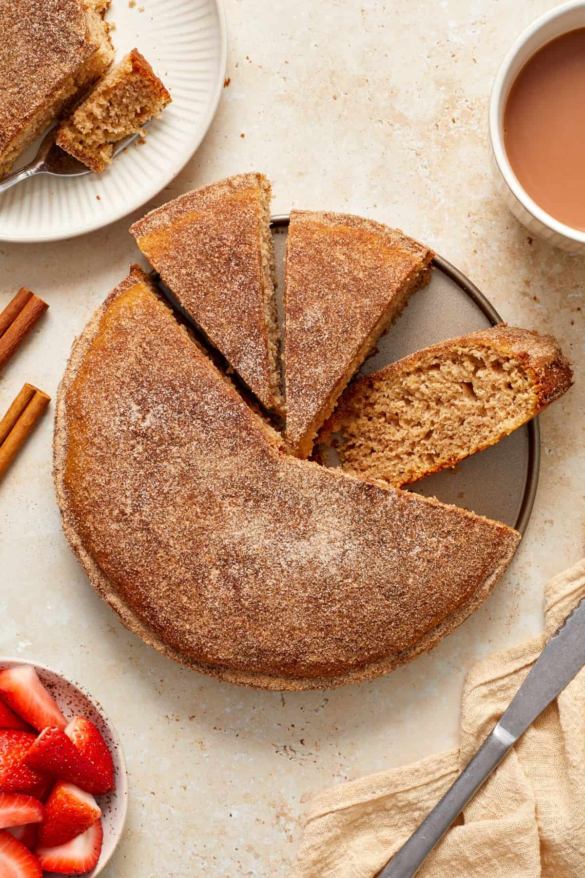 Cinnamon Tea Cake with three pieces cut, and one laying on the side showing the texture of the cake.