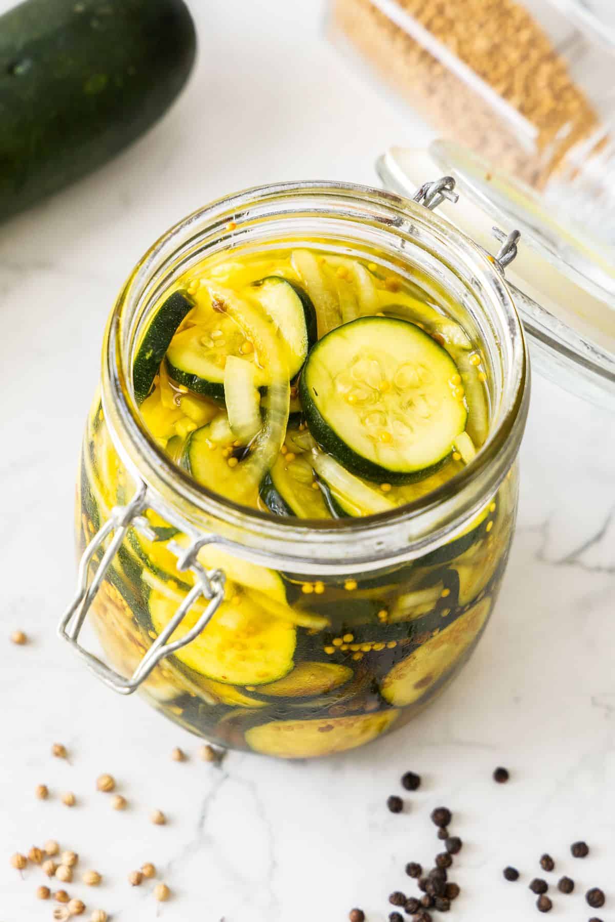 Jar of Pickled Zucchini, with some of the spices and seasonings used around the edge.