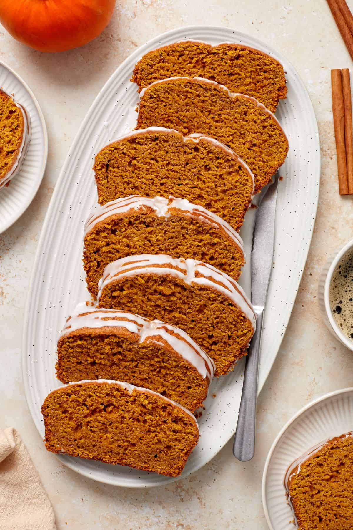 Slices of Pumpkin Loaf Cake on a white oval platter.
