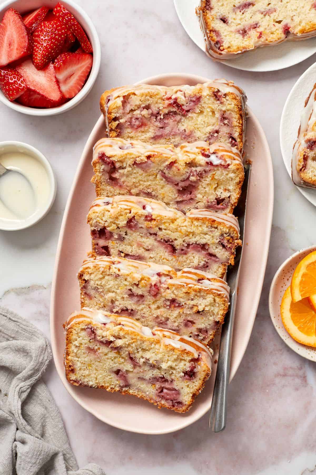 Slices of Strawberry Loaf Cake on a pink oval platter.