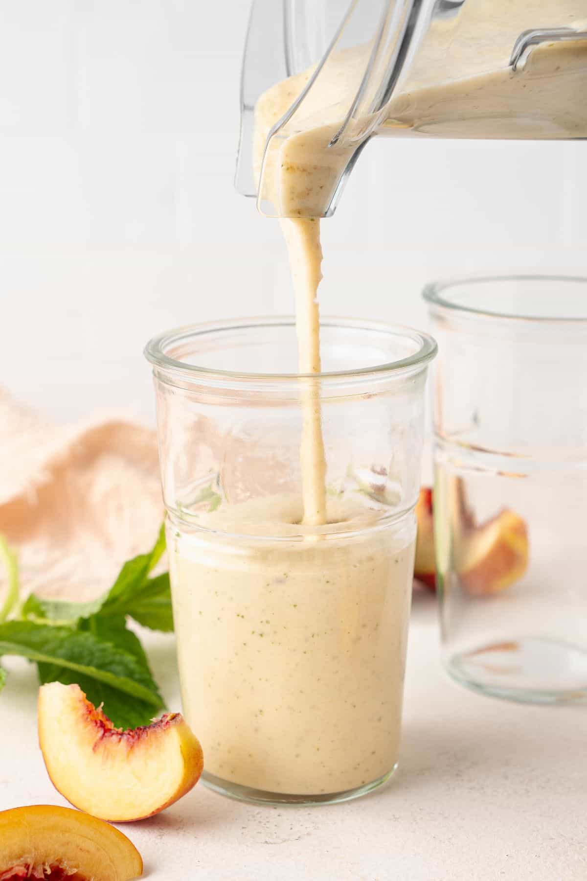 Peach and Banana Smoothie being poured into a glass from the blender.