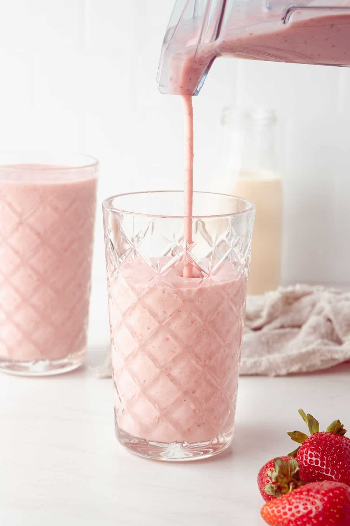 Strawberry and Banana Smoothie being poured into a glass from the blender.