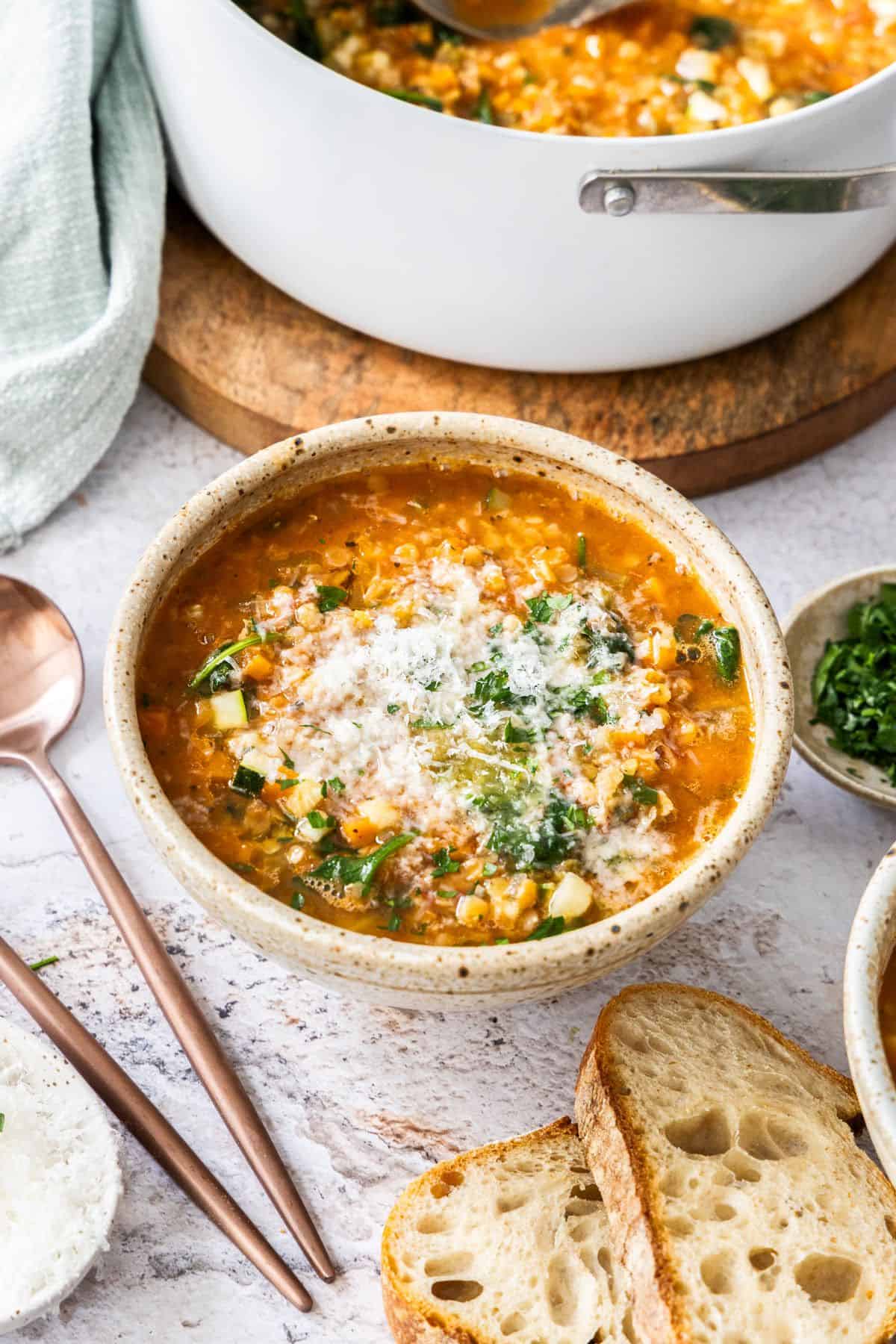 A bowl of Red Lentil Soup, with some Parmesan Cheese on top.