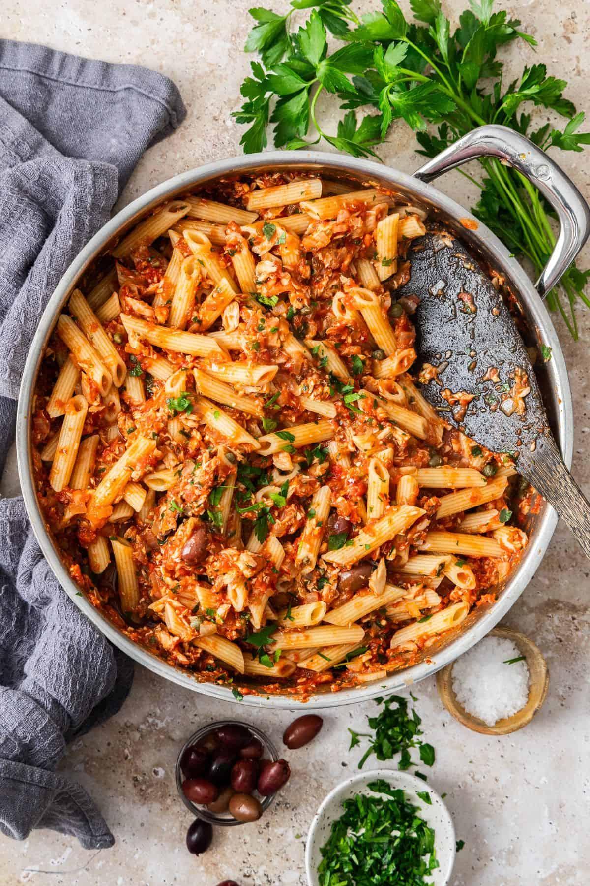 Large pan with the cooked Spicy Tuna and Tomato Pasta, ready to serve with a wooden spoon.