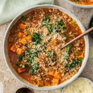 Bowl of Mediterranean Vegetable and Barley Soup with a spoon in it.