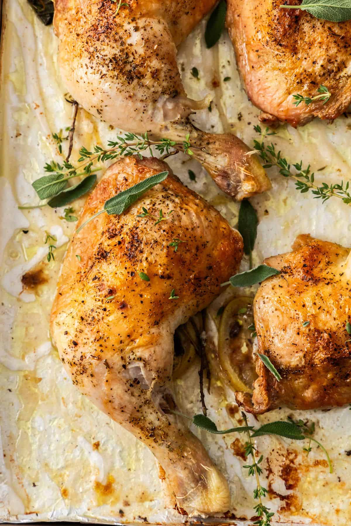 Roasted Chicken Marylands on a baking tray, garnished with some fresh herbs.