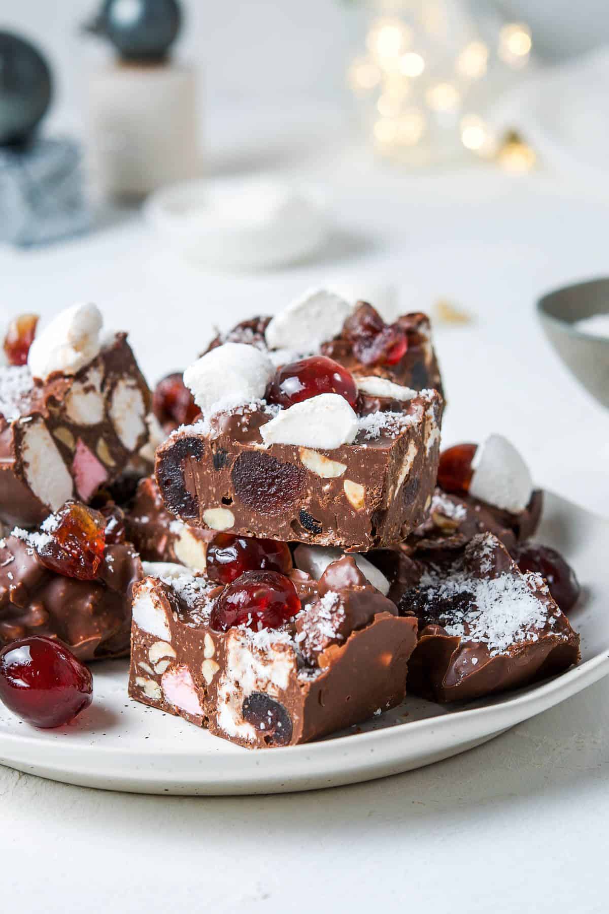 Round white plate with cut pieces of Rocky Road, sitting on a white bench top.