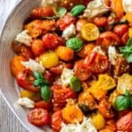 Round grey dish containing Roasted Cherry Tomato Caprese Salad.