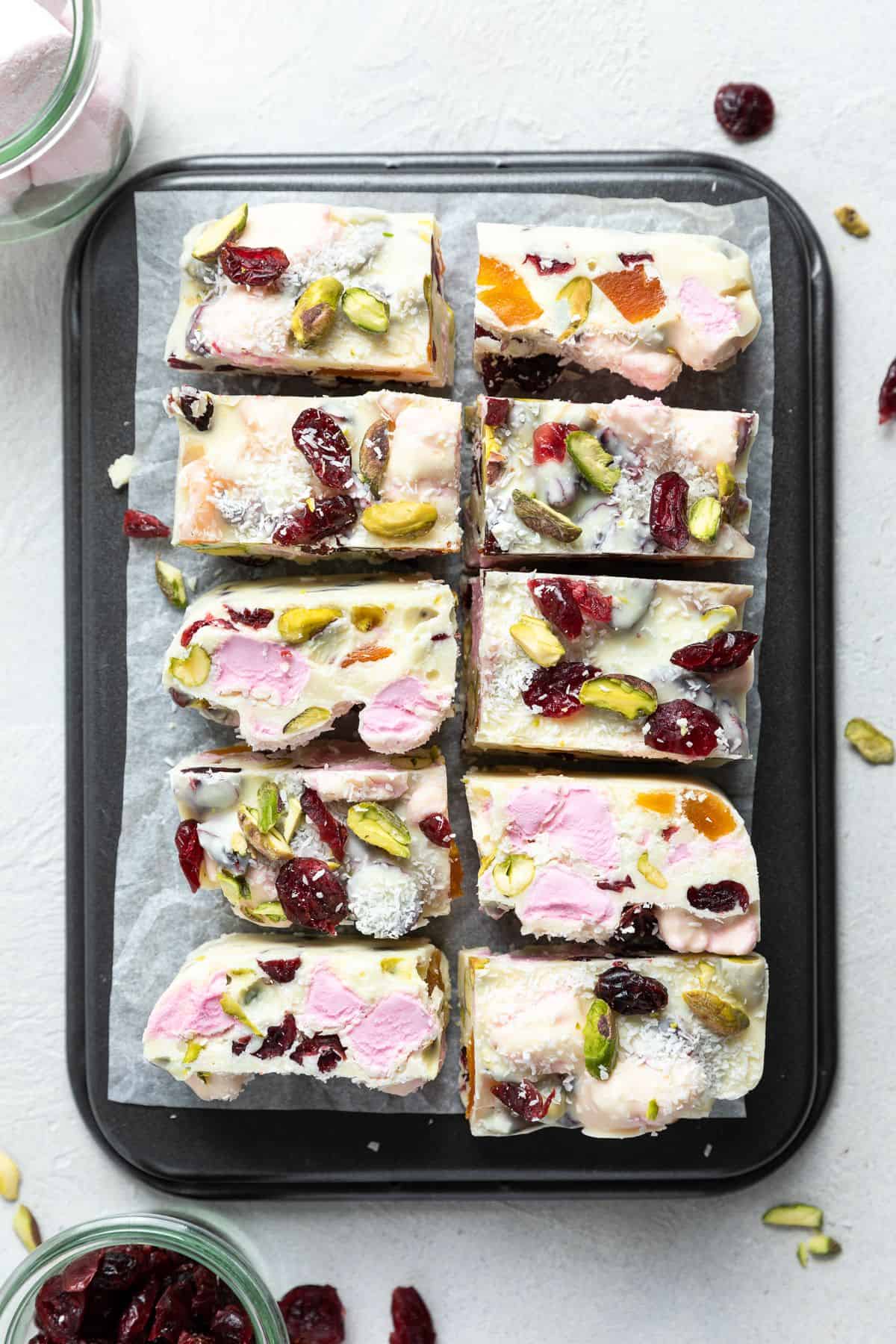 Cut pieces of White Chocolate Rocky Road on a piece of baking paper sitting on a baking tray.