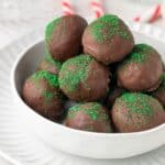 Round white dish of Chocolate Peppermint Truffles, sitting on a round white plate.