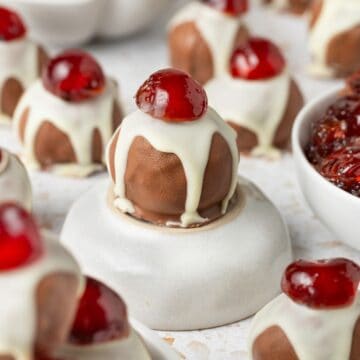 Christmas Fruit Mince Truffles on a marble board, with one sitting on a small round dish.