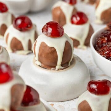 Christmas Fruit Mince Truffles on a marble board, with one sitting on a small round dish.