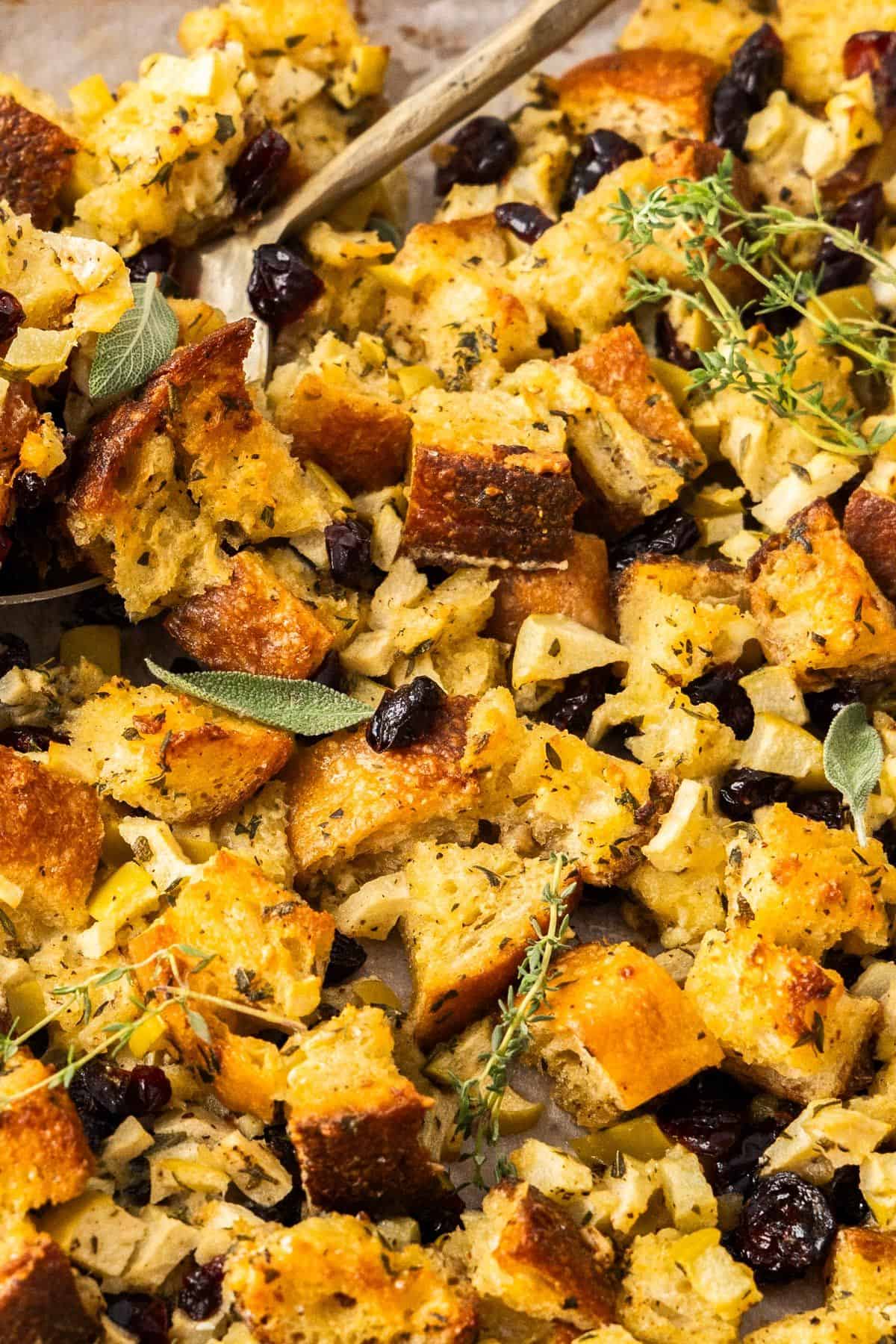 Crispy Sheet Pan Stuffing with a gold spoon scooping some up.