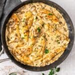 Frying pan with cooked Creamy Mushroom Chicken, garnished with a little chopped parsley.