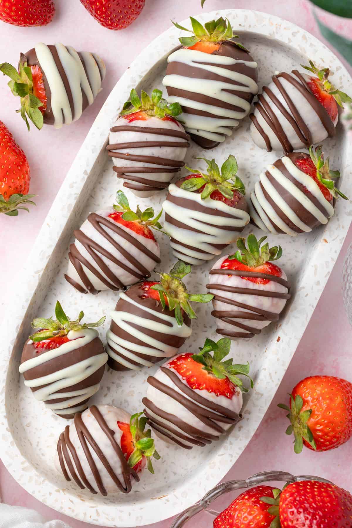 Marble platter with Chocolate Covered Strawberries, and some more fresh strawberries around the edge.
