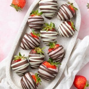 Marble platter with Chocolate Covered Strawberries, and some more fresh strawberries around the edge.