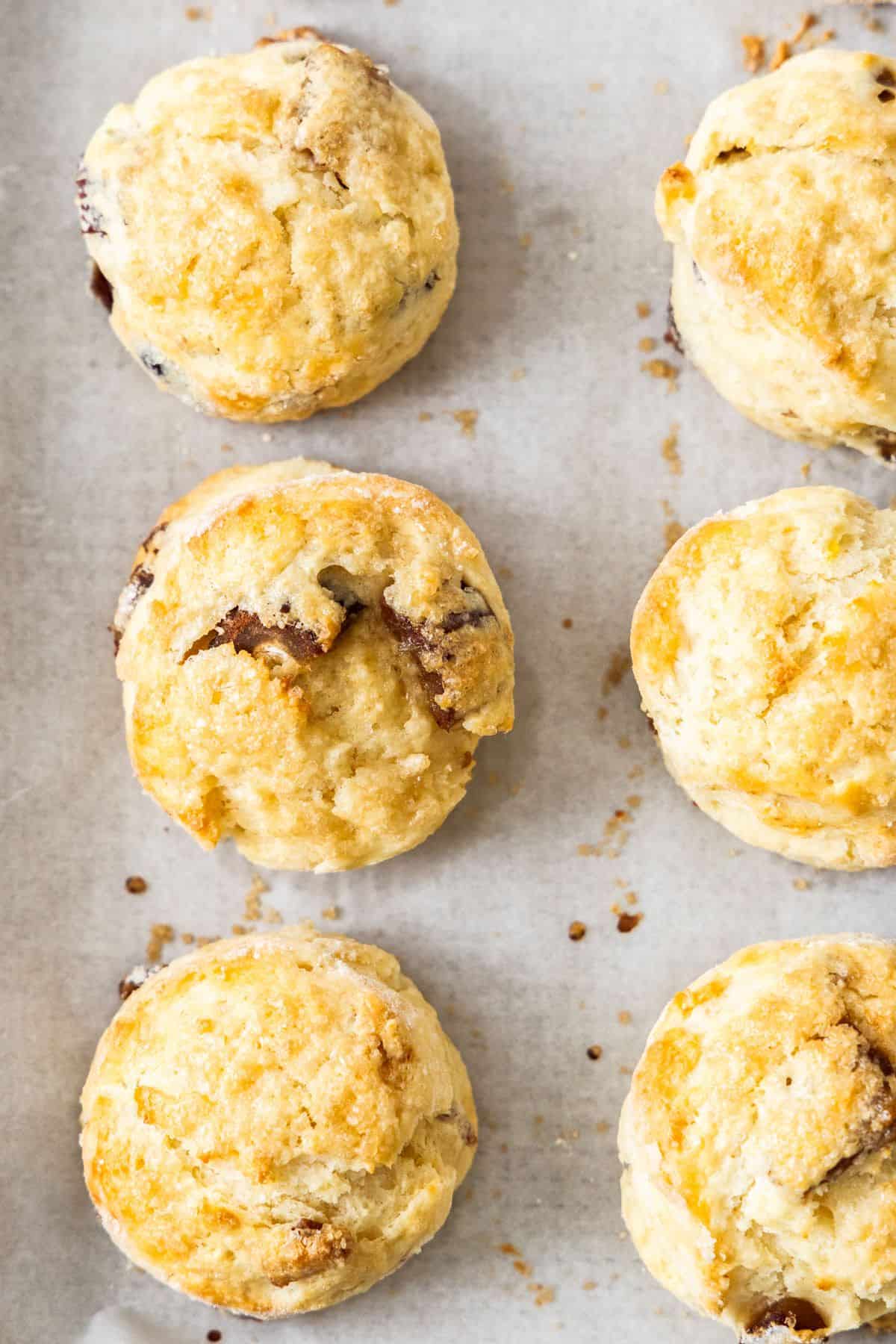 Six Date and Lemon Buttermilk Scones on a baking paper lined baking tray.